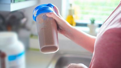 Is protein powder good for you? Image shows person holding protein shake