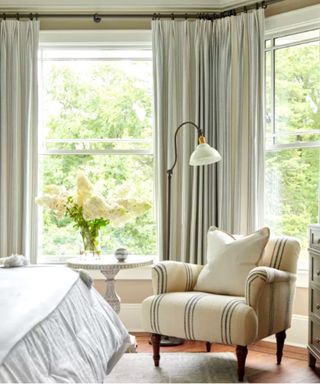 Beige neutral bedroom with linen curtains and overstuffed chair