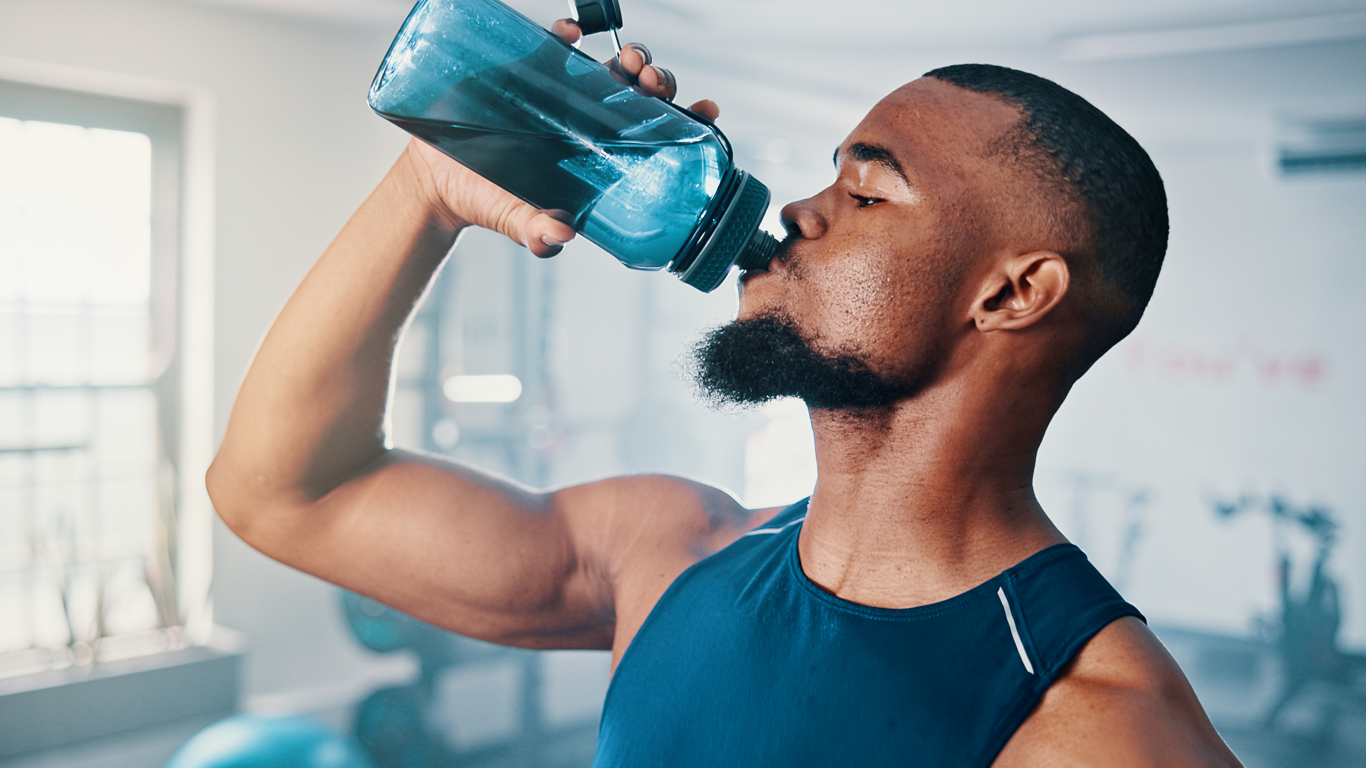A man drinking electrolytes at the gym