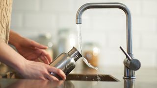 Cleaning a plastic free reusable water bottle in kitchen sink