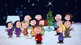 Animated image of Charlie Brown and Peanuts characters around Christmas tree