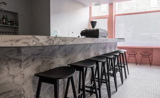 L-shaped grey and white marble-topped bar