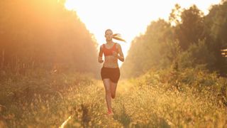 Young woman running in forest