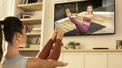 woman stretching with Peloton TV app