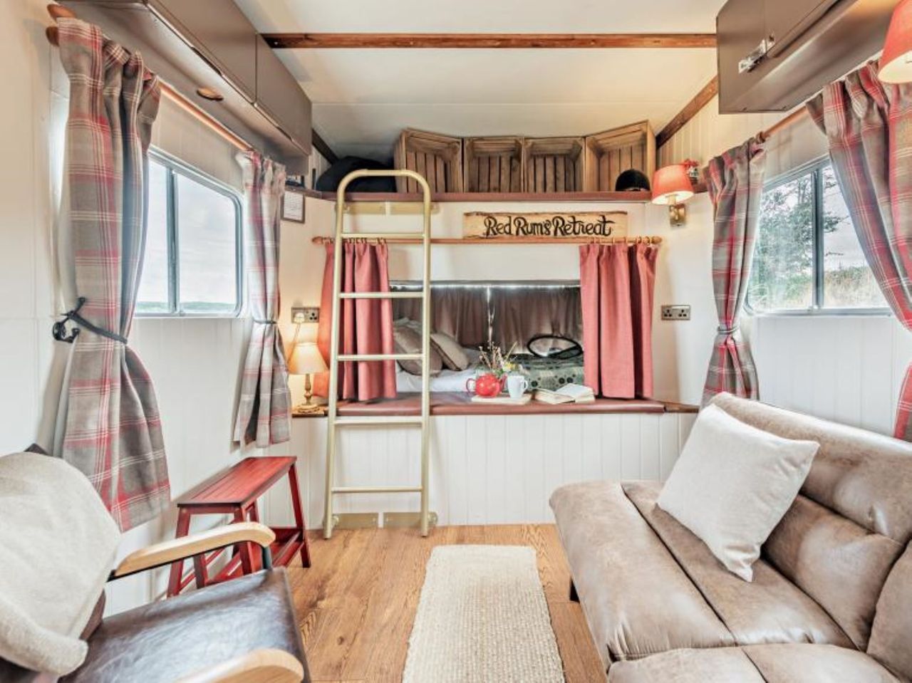 The bedroom has storage above the bed and seating and a bathroom connected to the bedroom
