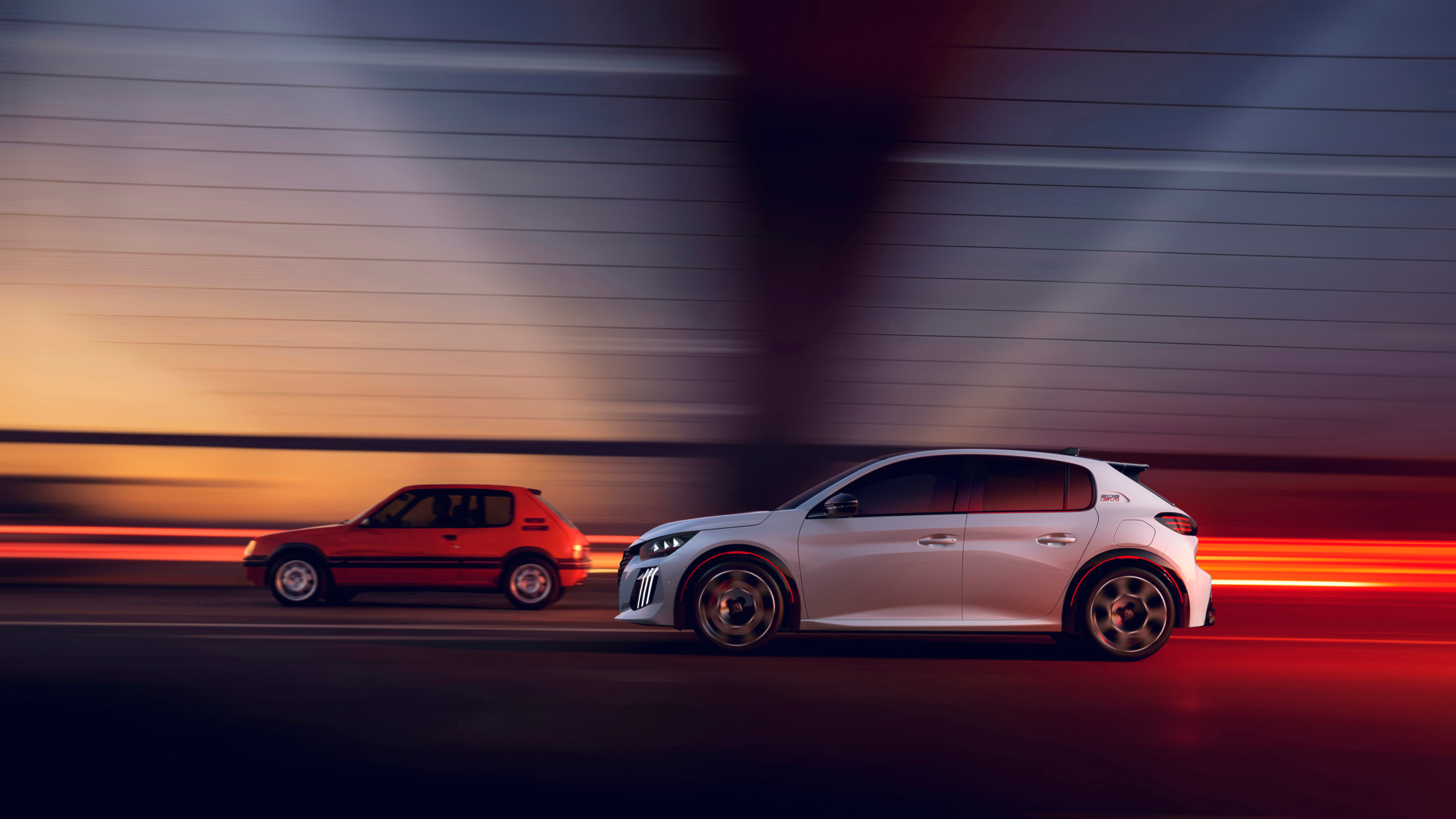 The original 205 GTi alongside the new Peugeot E-208 GTi