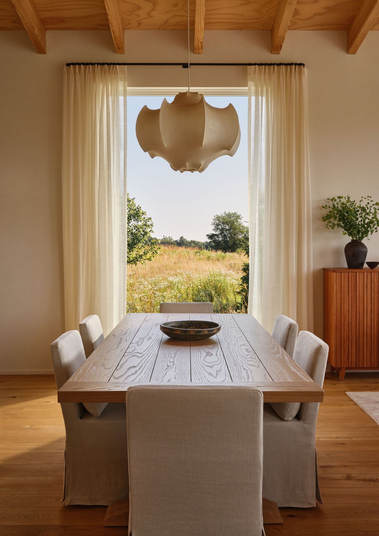 dining room with a large table, several chairs, and a pendant light