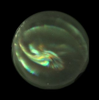 The aurora as seen as a color composite image from the NORUSCA II camera. Three bands were combined to make the image. Each band was assigned a different color -- red, green, and blue -- to enhance the features of the aurora for analysis.