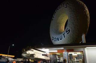 Space shuttle Endeavour is seen behind Randy's Donuts, an L.A. landmark on Manchester Blvd., Oct. 12, 2012.