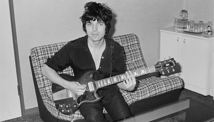 Brian James, seated with a Gibson SG guitar in London in 1977