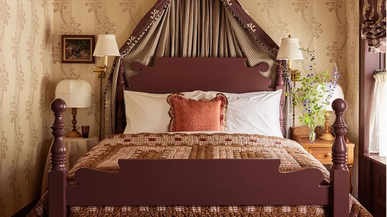 The Six Bells bedroom with floral wallpaper, patchwork quilt and bed coronet