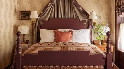 The Six Bells bedroom with floral wallpaper, patchwork quilt and bed coronet