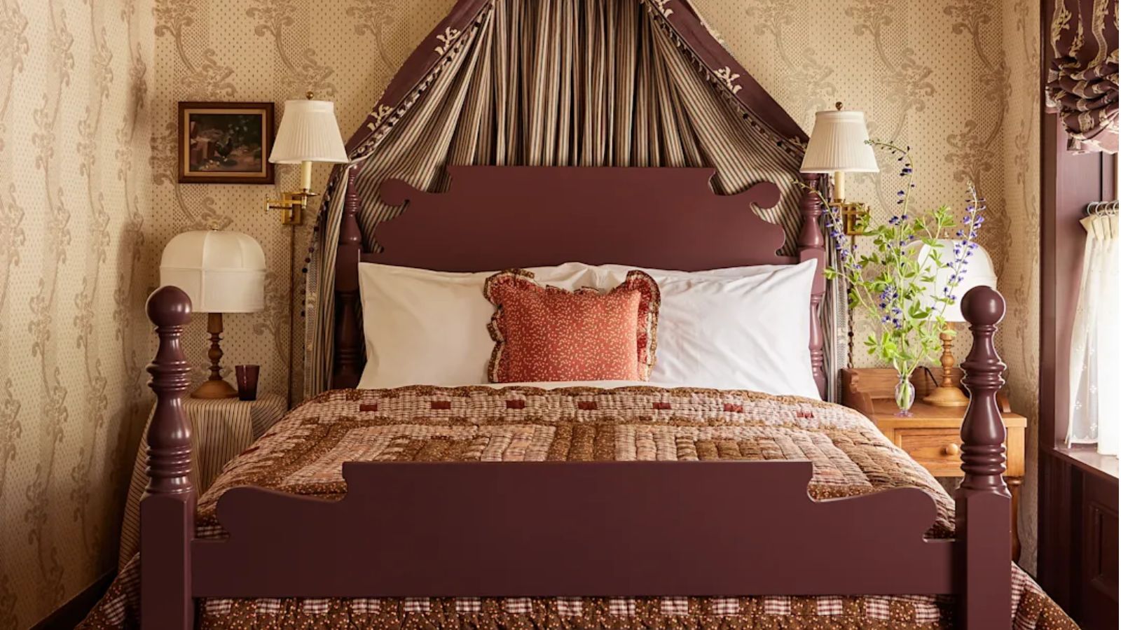 The Six Bells bedroom with floral wallpaper, patchwork quilt and bed coronet