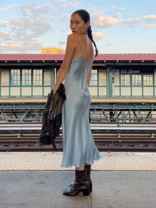 The influencer styles a baby blue dress with brown boots.
