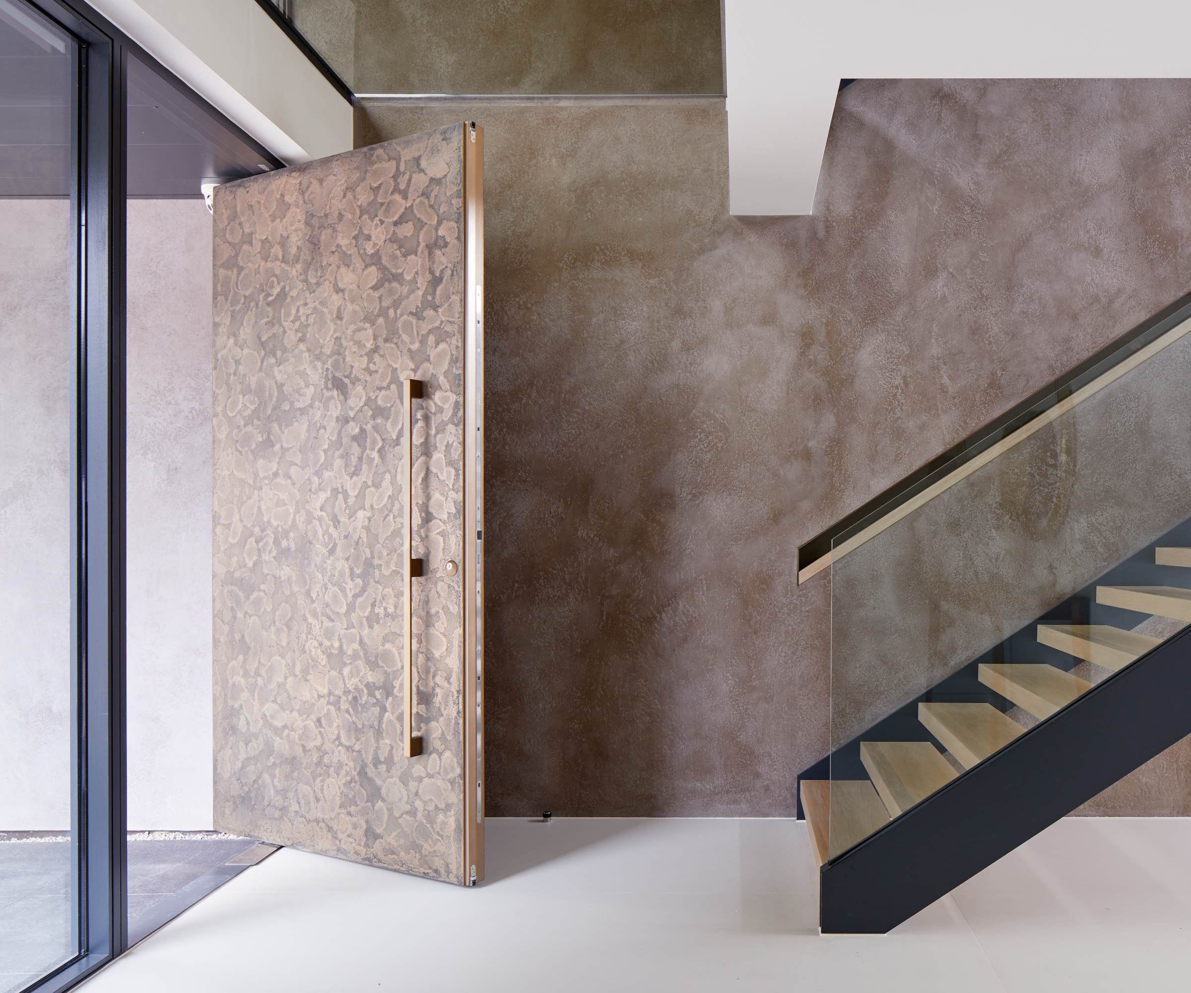 large bronze aged finish pivot front door