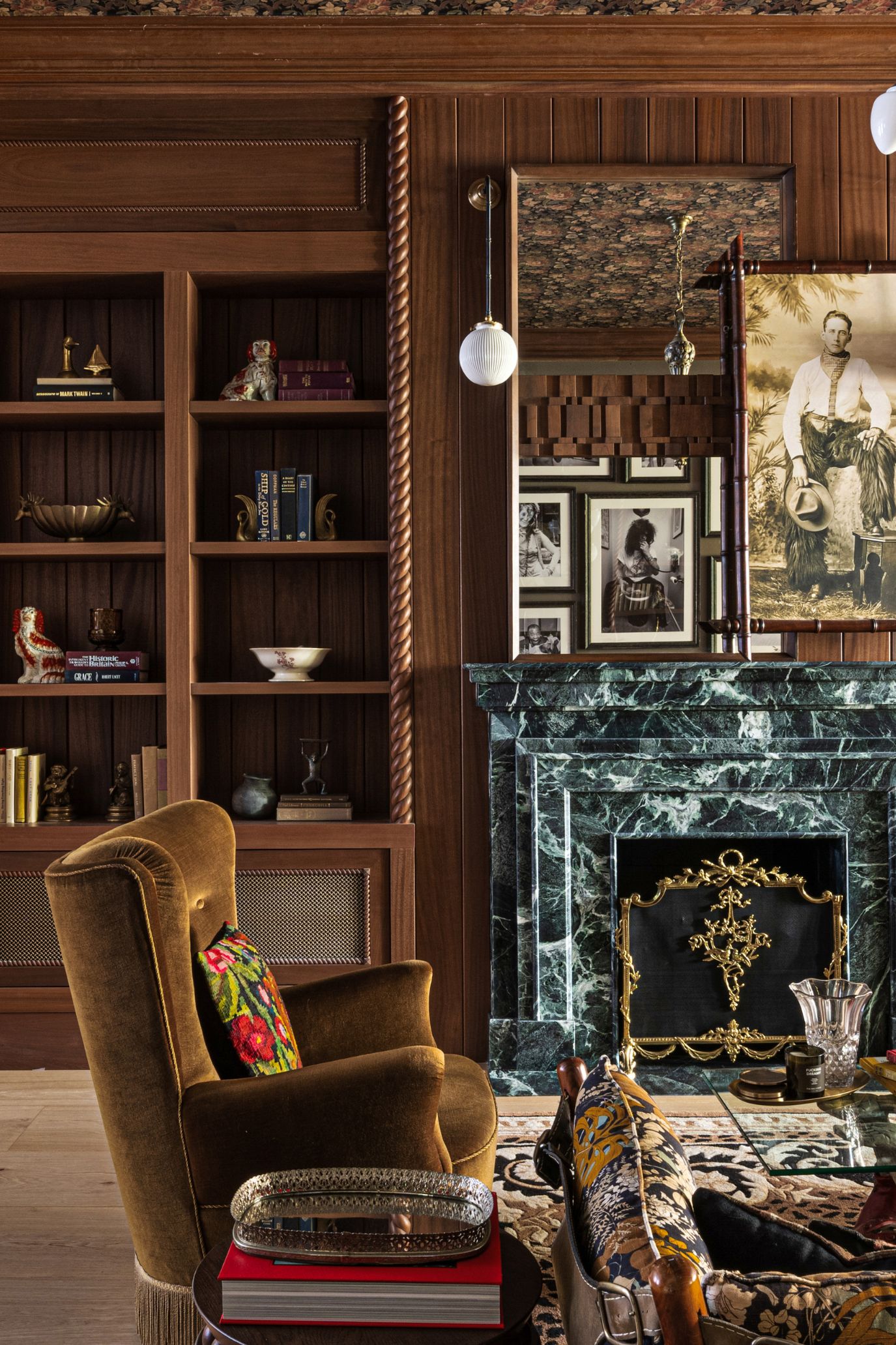NYC parlor room featuring warm woods, a green marble fireplace, and contemporary artwork