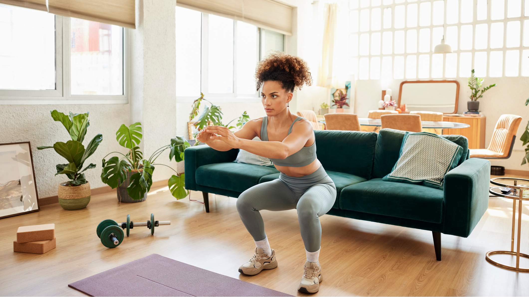 Woman performing the squat exercise in a domestic living area