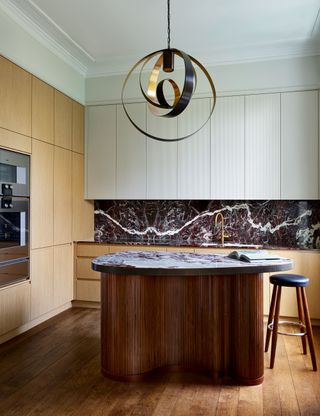 Modern kitchen with curved island and large pendant