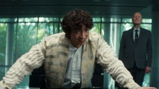 Boy Kavalier smiling as he leans on a table with his hands in Alien: Earth episode 6