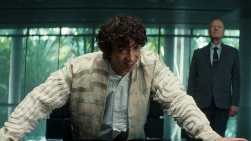 Boy Kavalier smiling as he leans on a table with his hands in Alien: Earth episode 6