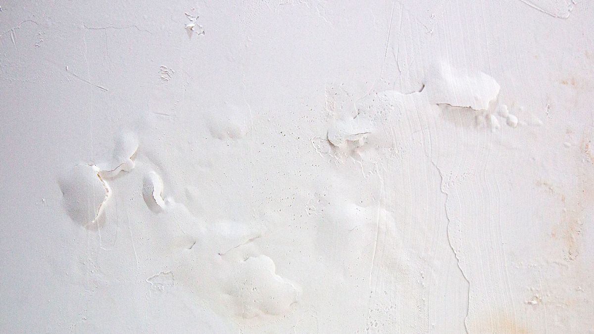 Close up of bubbling paint on white wall