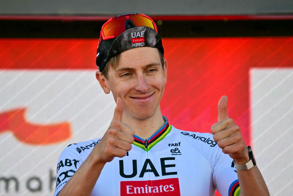 Tadej Pogacar gestures on the podium after winning the third stage of the UAE Tour 2025