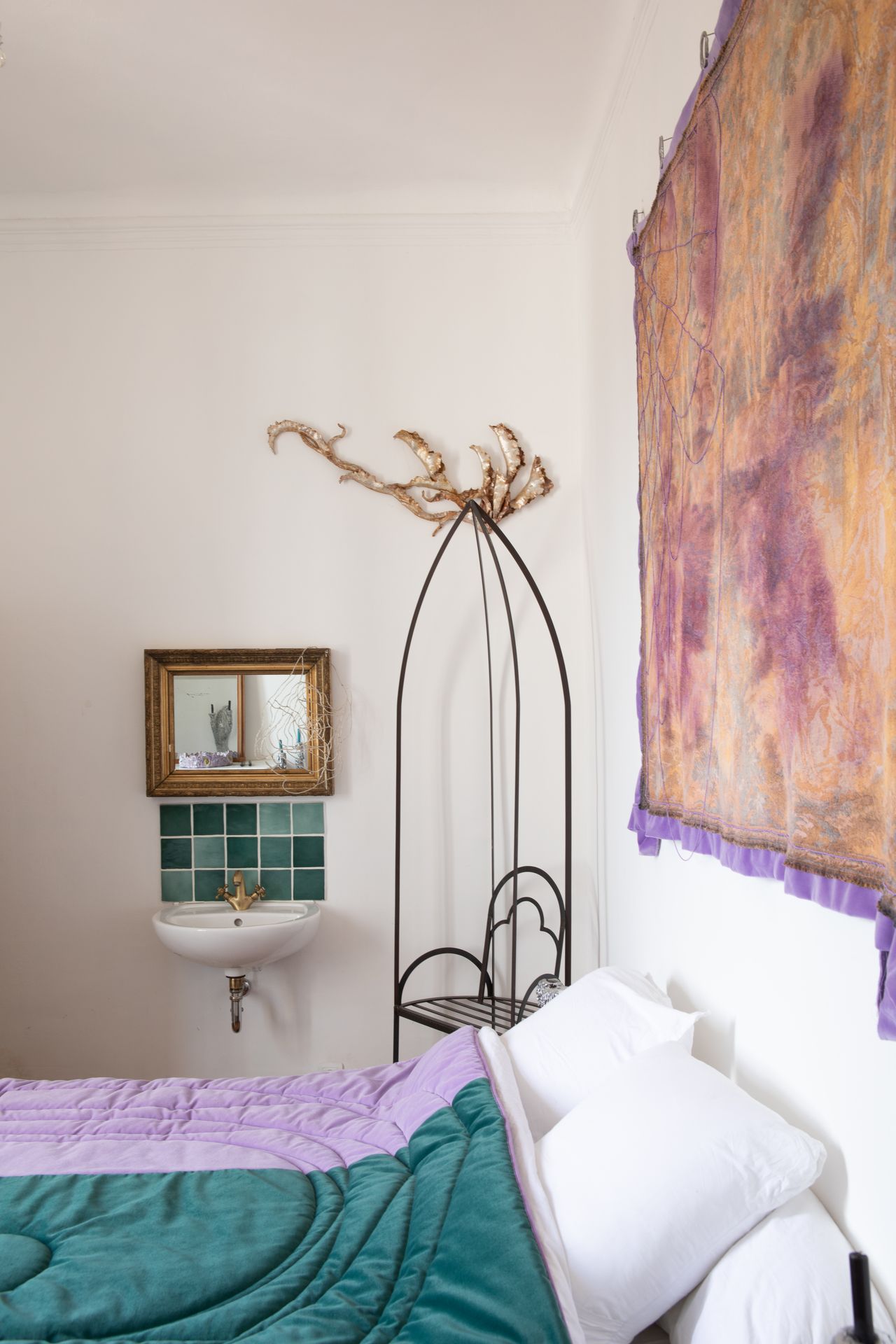 A beautifully renovated, palatial building with frescoed ceilings and walls houses an array of gothic-inspired furniture that simultaneously nod to contemporary and classical design, including tapestries, chandeliers, and velvety seats, and wooden decor.