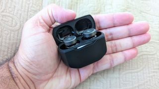 Edifier W240TN ANC earbuds in charging case placed in palm of hand