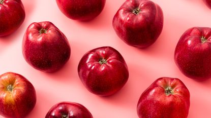 red apples on a pink background to signify the apple body shape type