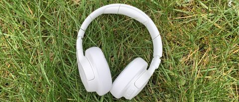 the jbl tune 750btnc headphones in white pictured on a grass background