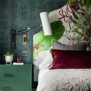 Green bedroom with upholstered headboard and mulberry cushion