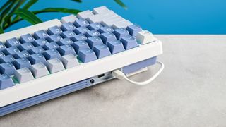 A Royal Kludge M75 wireless mechanical keyboard with blue keycaps