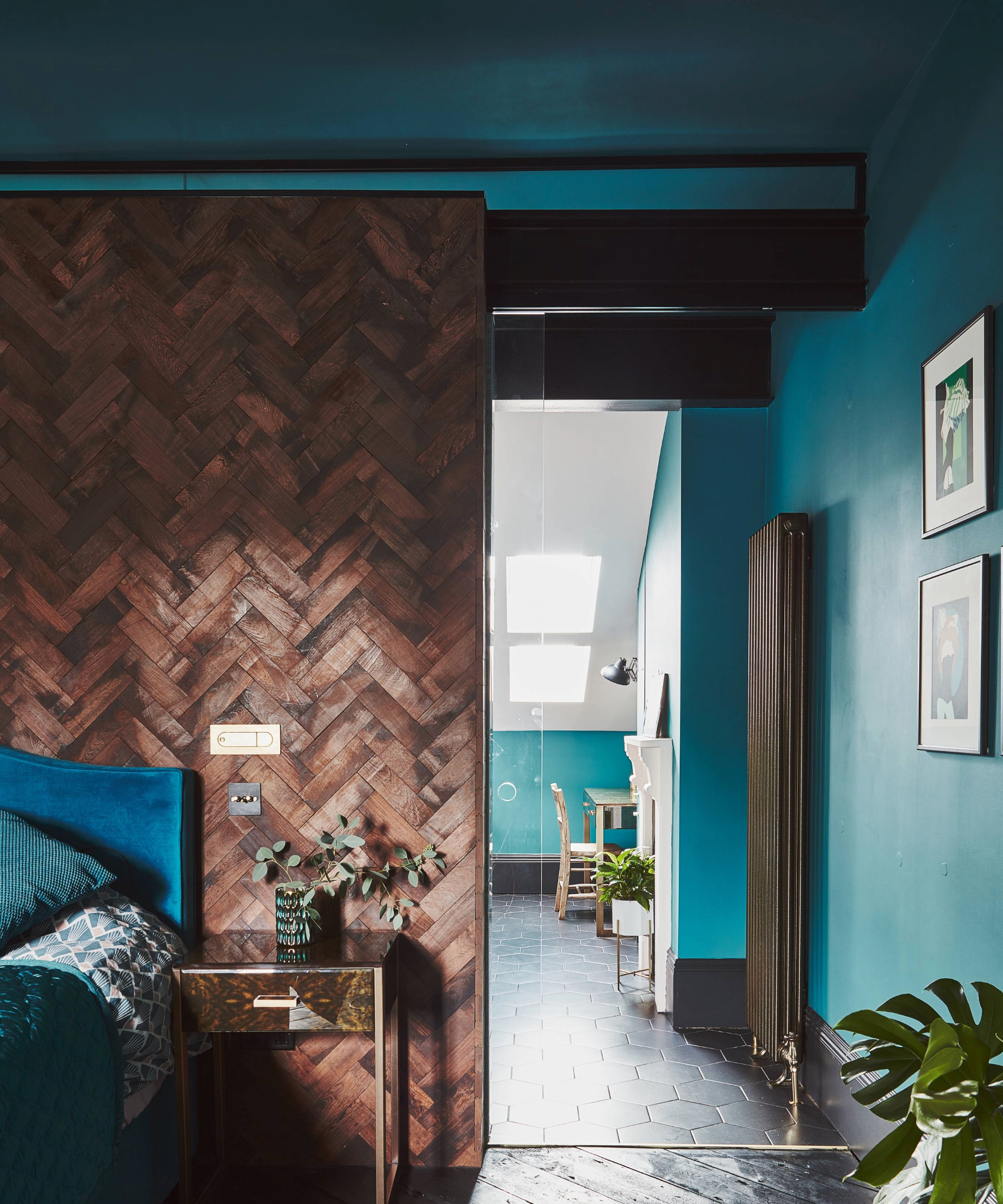 Blue and wooden bedroom where the colour leads onto the bathroom