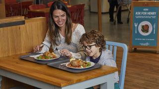 A smiling mother and child tuck into a hot meal at a Morrisons cafe