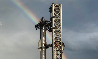 A rainbow arcs behind SpaceX's stacked Starship vehicle at the company's Starbase facility in South Texas. The company posted this photo on Twitter on April 11, 2023.