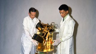 George Carruthers, right, and William Conway, left, examine the golden-hued Far Ultraviolet Camera/Spectrograph, which would become the first moon-based observatory.