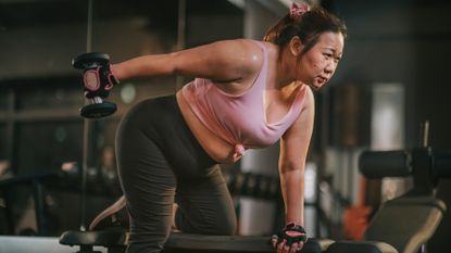 Woman trains her arms with a dumbbell