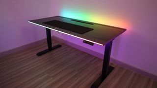 Cooler Master GD160 ARGB gaming desk on a wooden floor