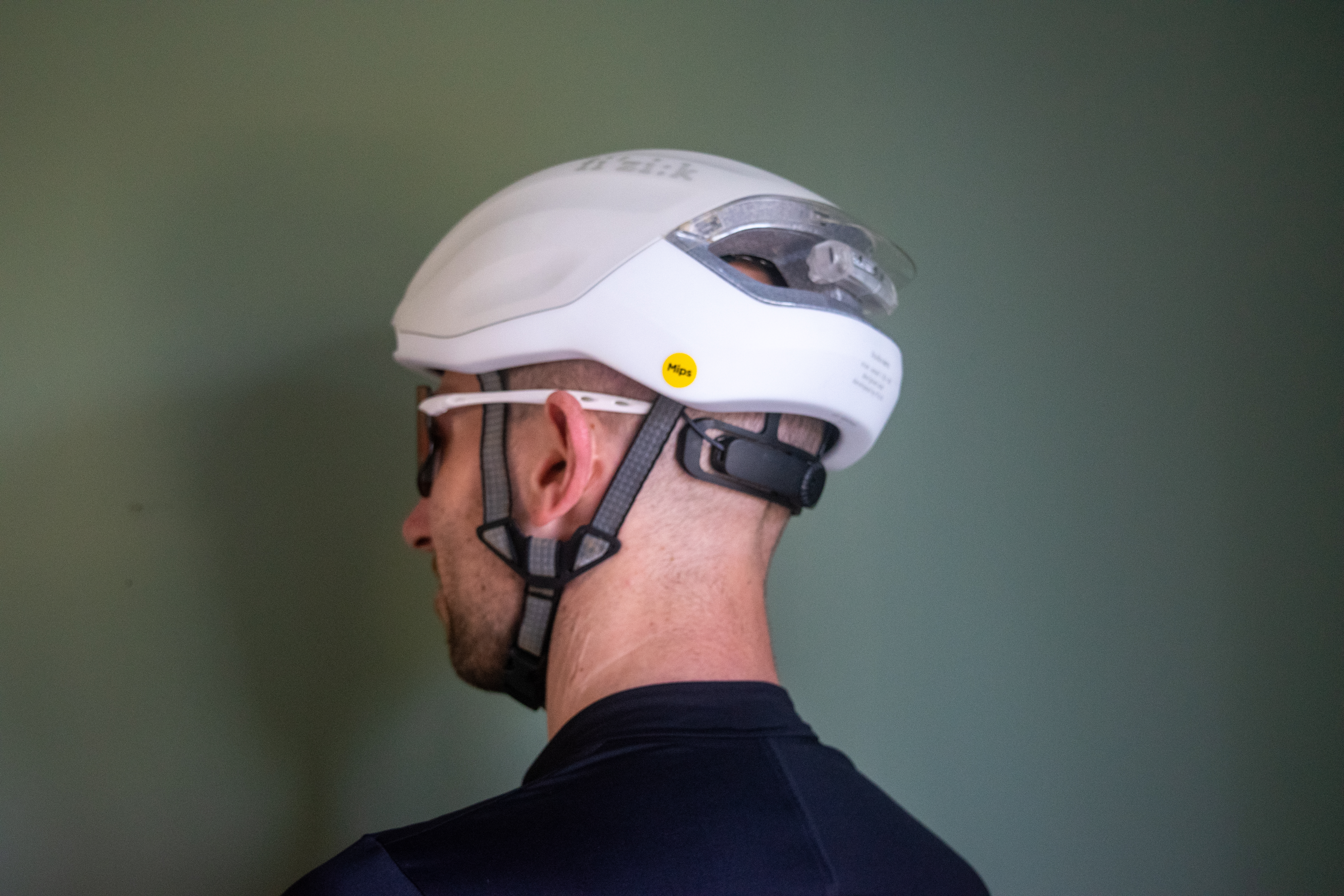 A man wearing a white fizik kudo aero helmet