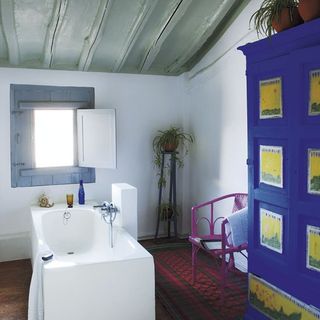 bathroom with white bathtub wicker chair and bathroom cabinet