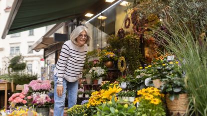 Mature woman looking at flowers outside a florist