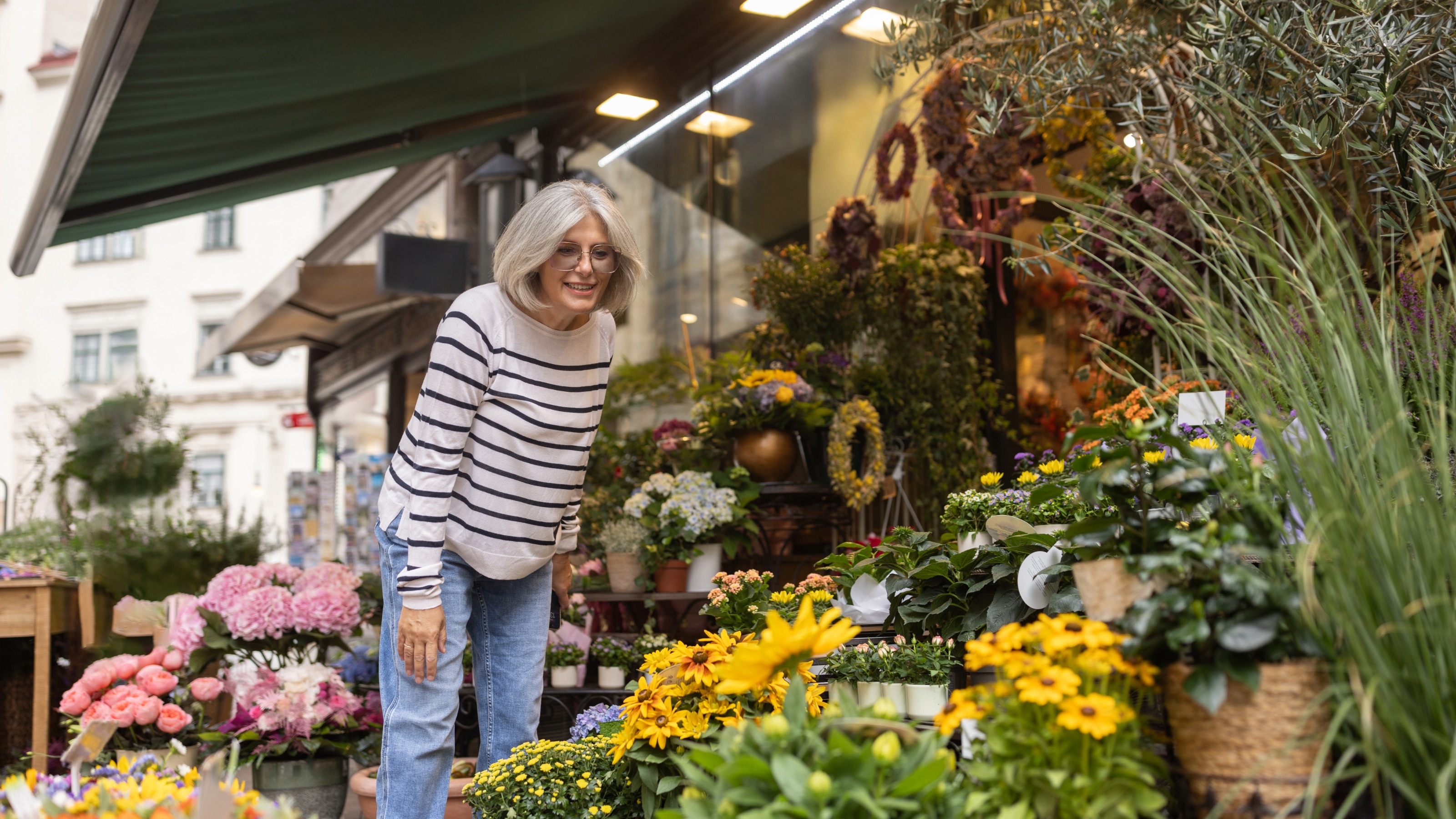 Mature woman looking at flowers outside a florist