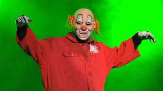 Clown on stage bathed in green light