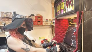 Lilith Walther sits in front of the Nightmare Kart arcade cabinet at the Arcade Commons workshop