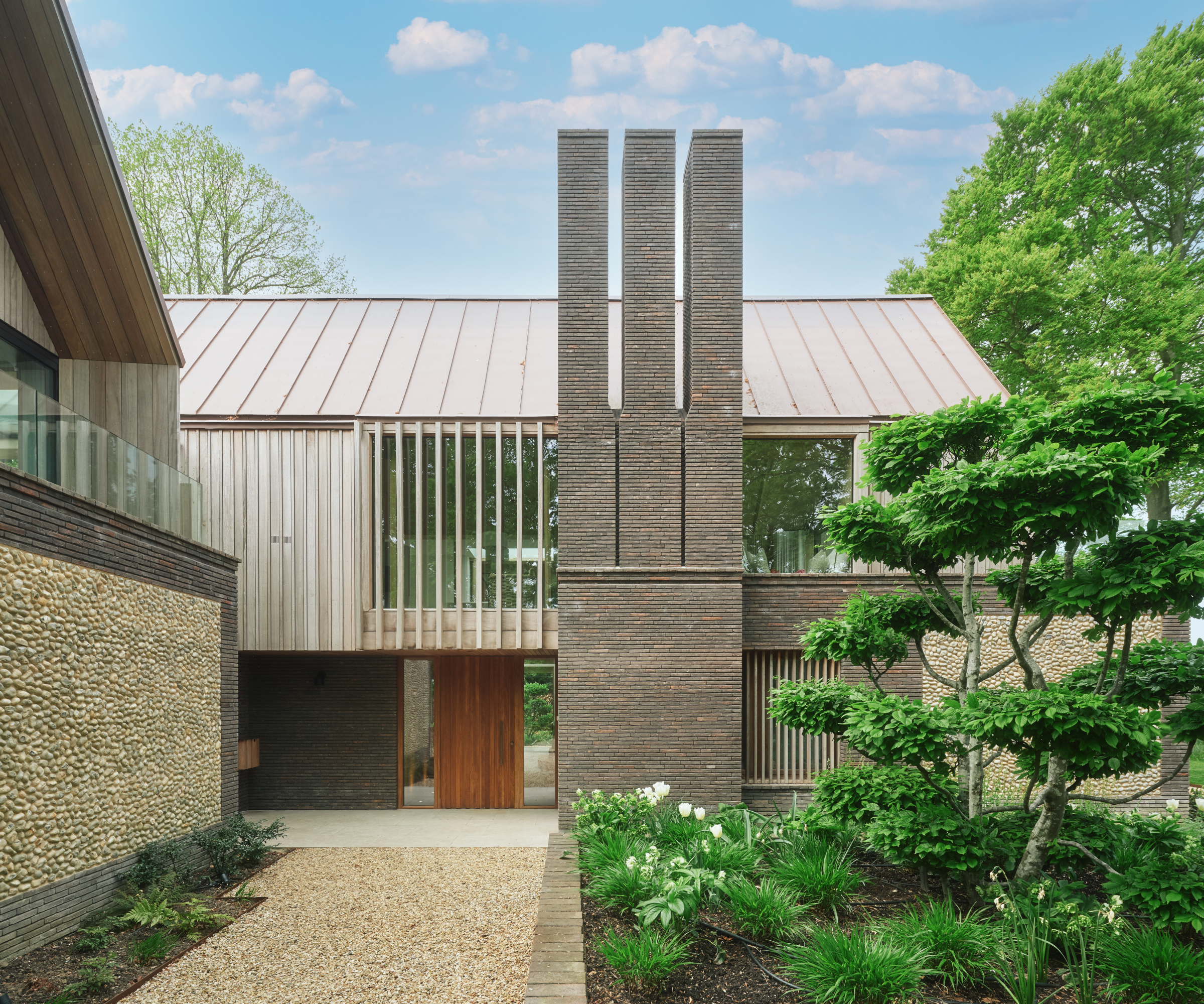 resin bound pathway leading to contemporary home with large wooden front door