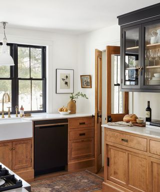 Farmhouse kitchen with wooden base cabinets and black wall cabinet