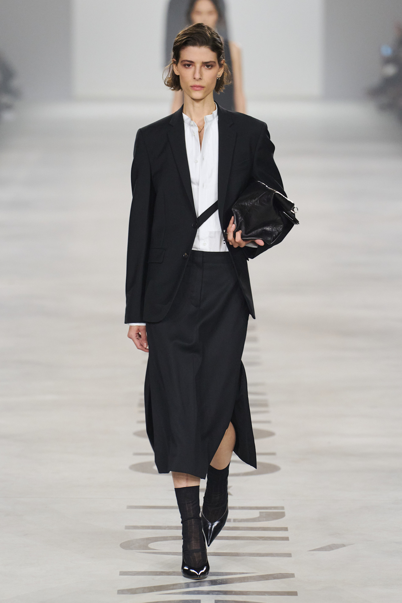 Model walks the A/W 26 runway wearing skirt suits