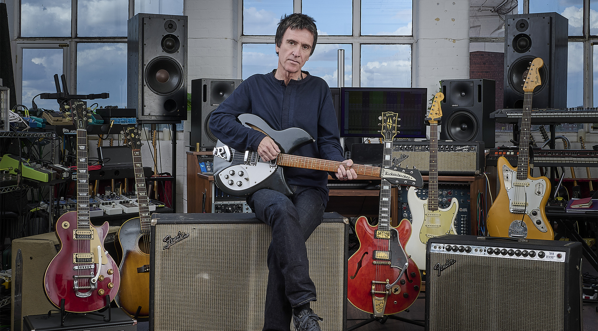 Johnny Marr poses with guitars and amps he's auctioning via Christies
