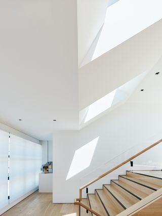 White interior with staircase lit from above at Four One Nine by Síol Studios