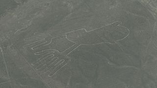 Aerial photo of Nazca lines in Peru. This geoglyph looks like a line drawing of a a pair of human hands.